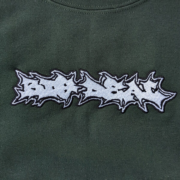 Big Deal logo embroidery close up on a green crewneck sweater